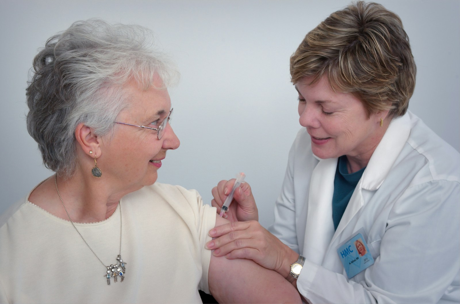 A nurse checking on an elderly woman during a home visit